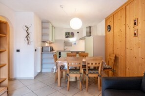 Una cocina moderna con comedor, armarios de madera y una lámpara colgante grande.