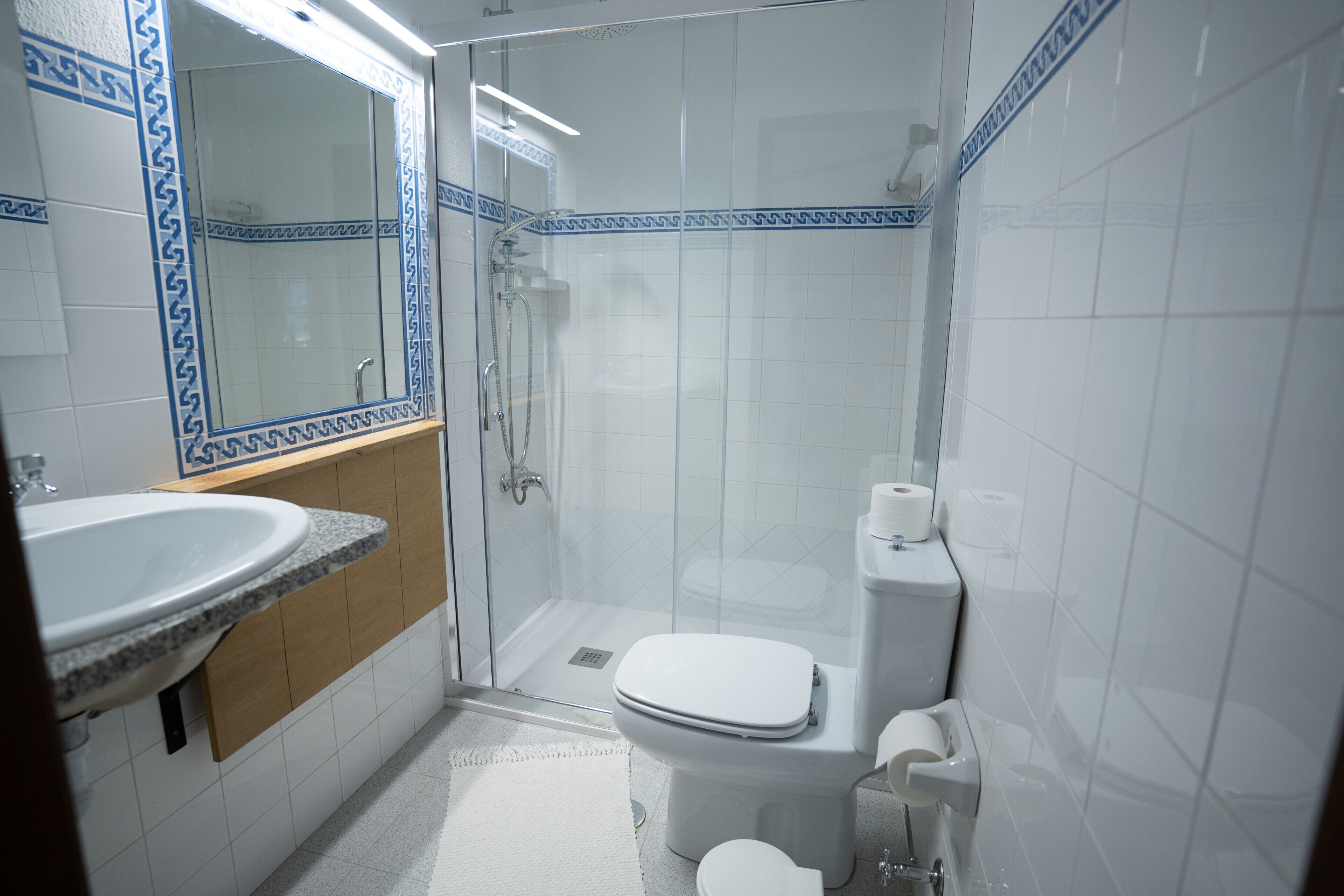 A bathroom with a shower, toilet, and sink.