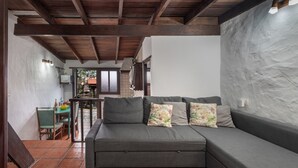 Un espace de vie moderne avec un canapé gris, une table à manger et une cuisine en arrière-plan.
