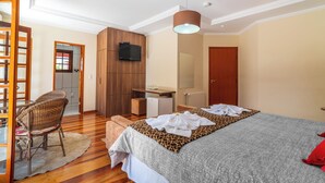A hotel room with a bed, a television, a desk, and a chair. - Serra do Jordão by Concavus (Campos do Jordão)