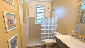 A compact bathroom with a shower, toilet, and sink.