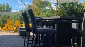 An outdoor patio area with a table and chairs, a string of lights, and a large umbrella. - Charming 3-bedroom cottage in enchanting Citrus Heights with AC, WiFi (Citrus Heights)