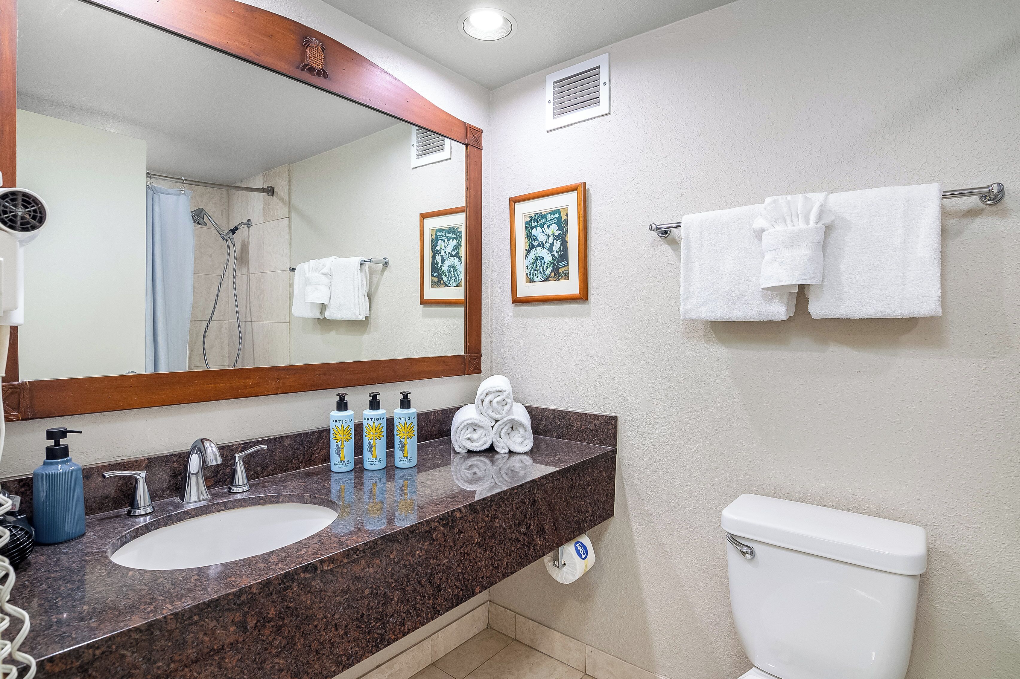 A bathroom with a sink, mirror, towel rack, and toilet.