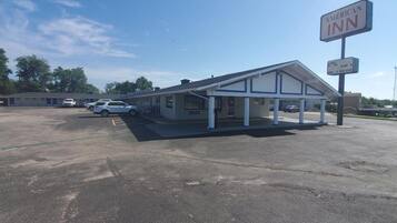 Un motel con zona de estacionamiento techada y un letrero que indica que es un American Inn.
