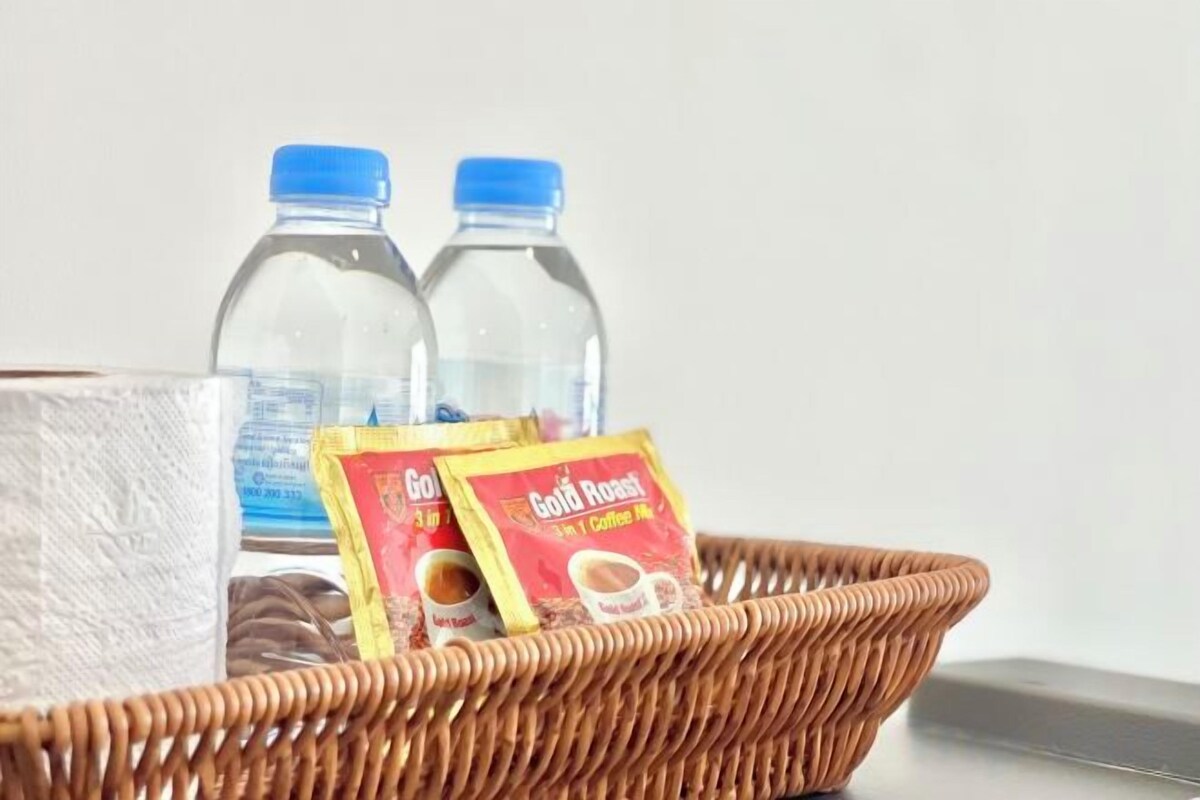 A wicker basket containing a tissue box, two water bottles, and two GoGoMac coffee packets.