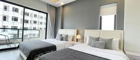 A hotel room with two beds, a balcony, and a large window.