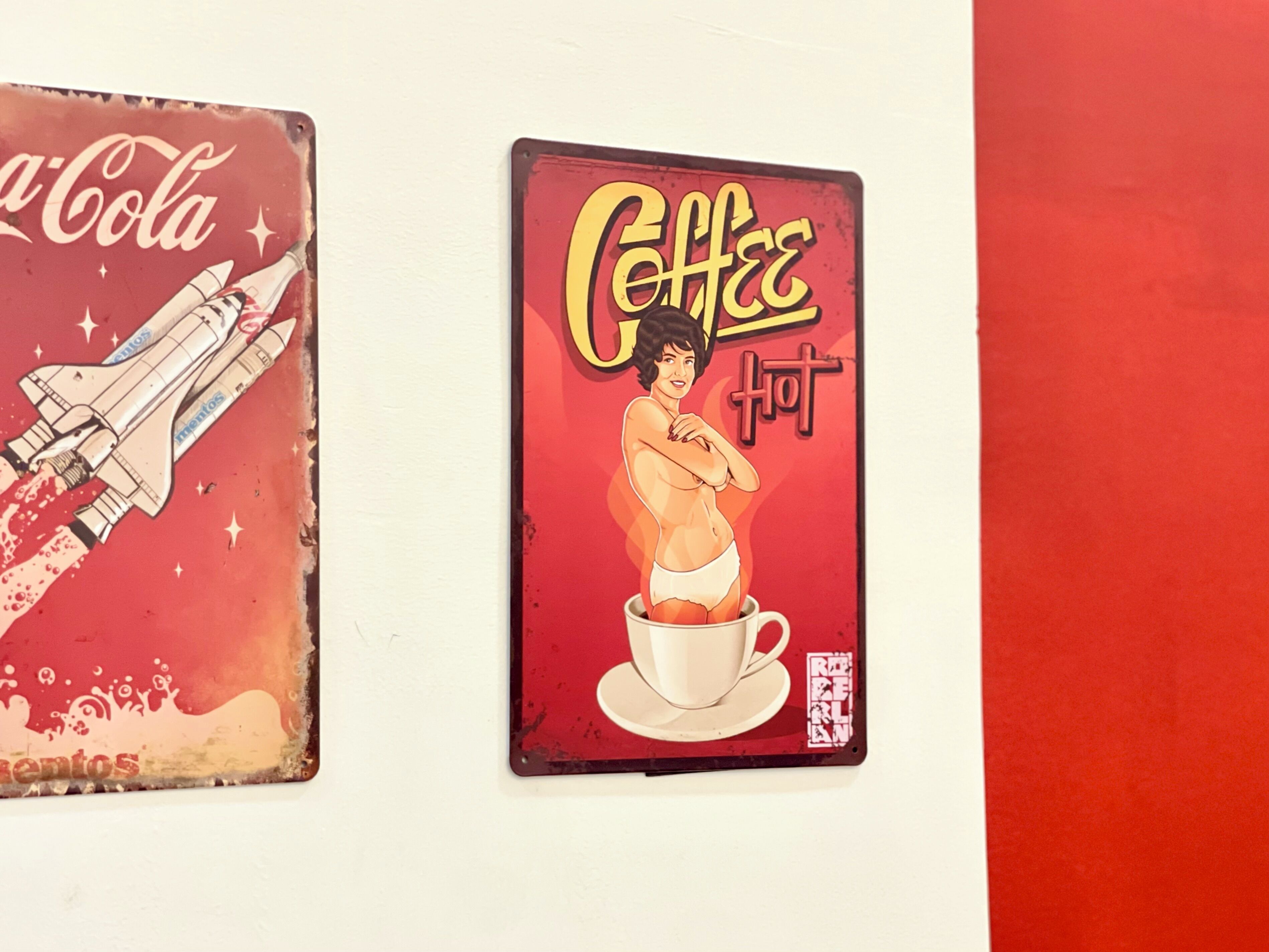Two vintage signs, one with a space shuttle and the other with a coffee cup illustration.