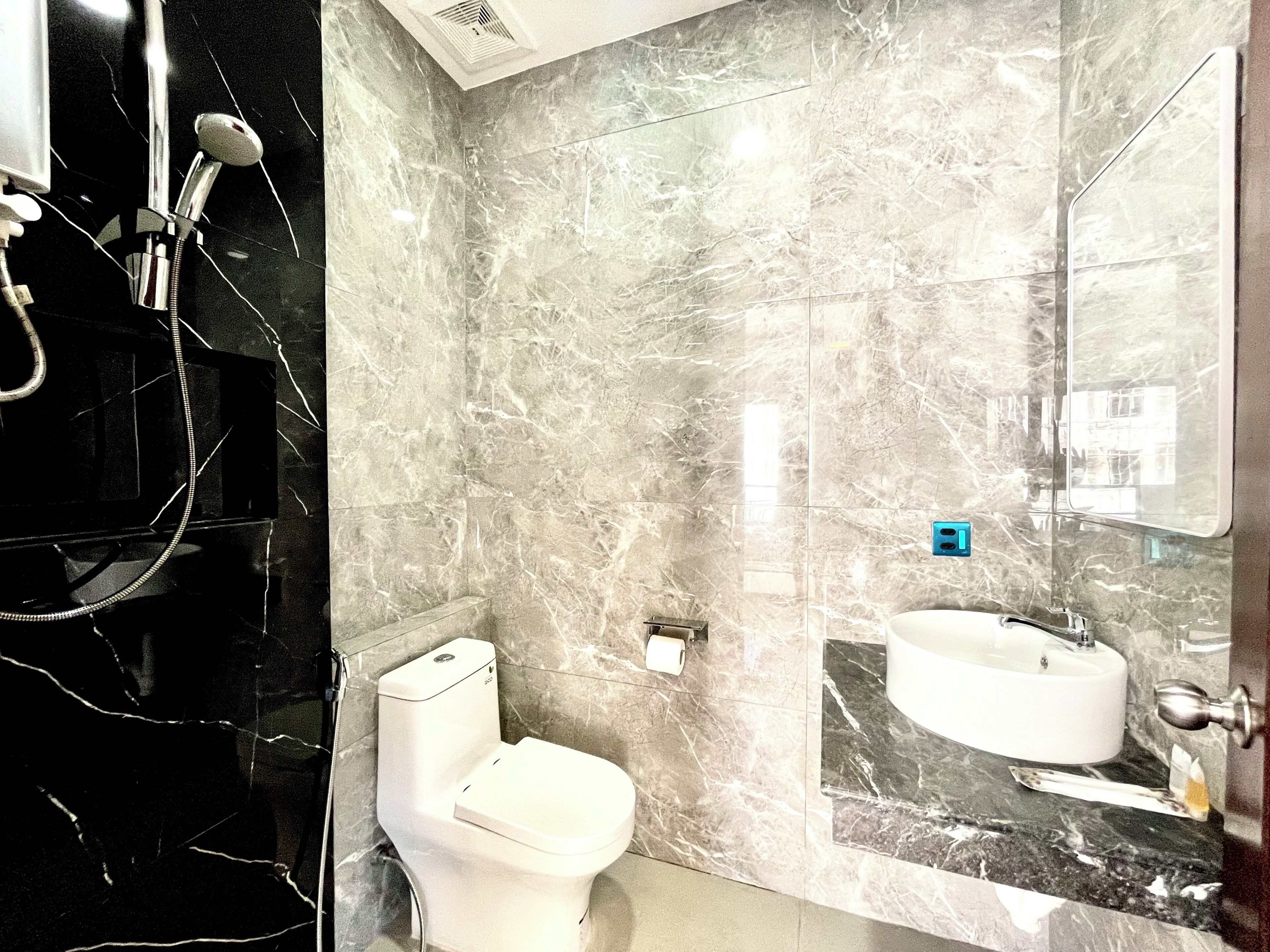 A bathroom with a toilet, a sink, and a shower.