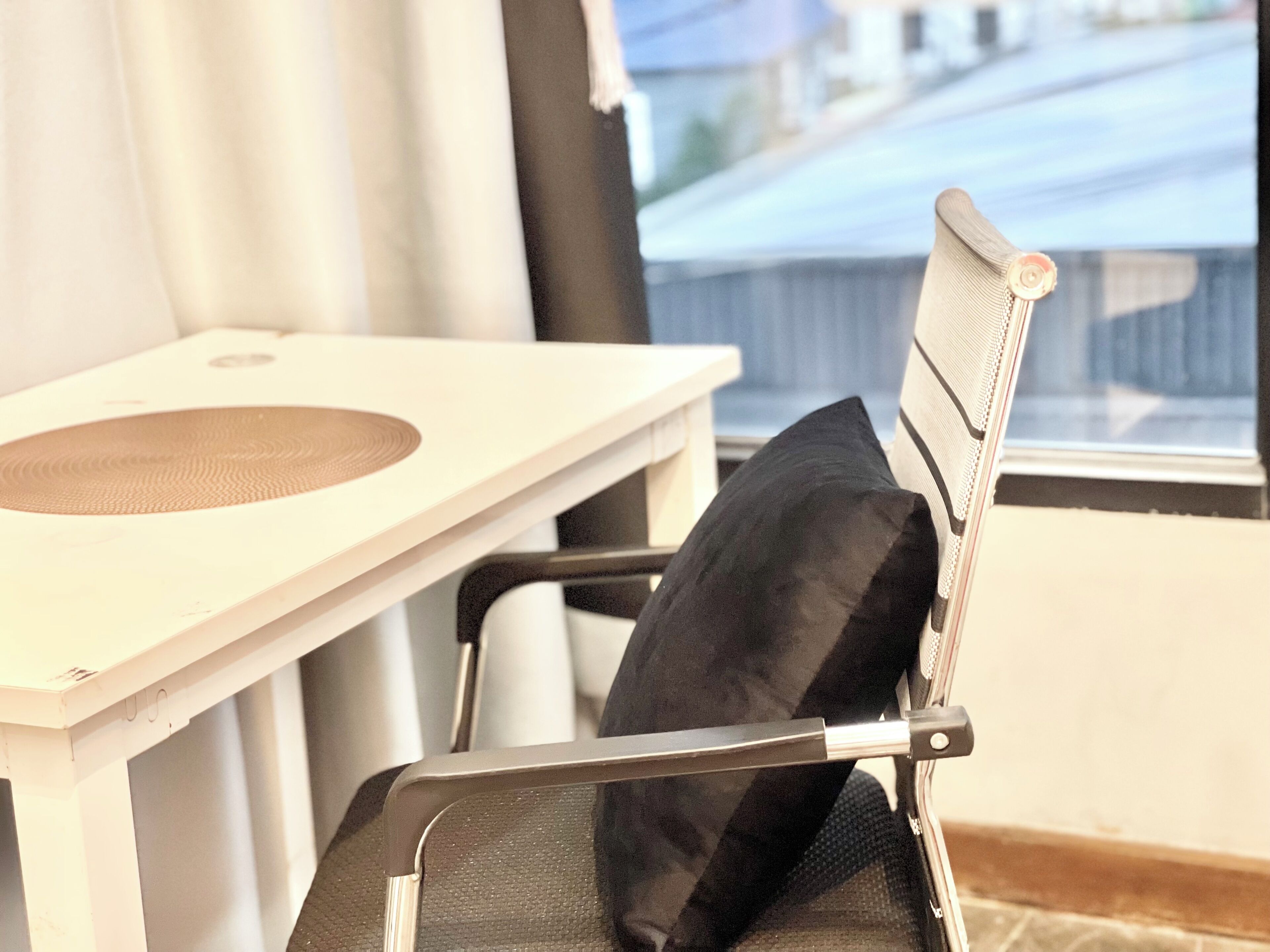 A chair with a headrest and a table with a circular object on it.