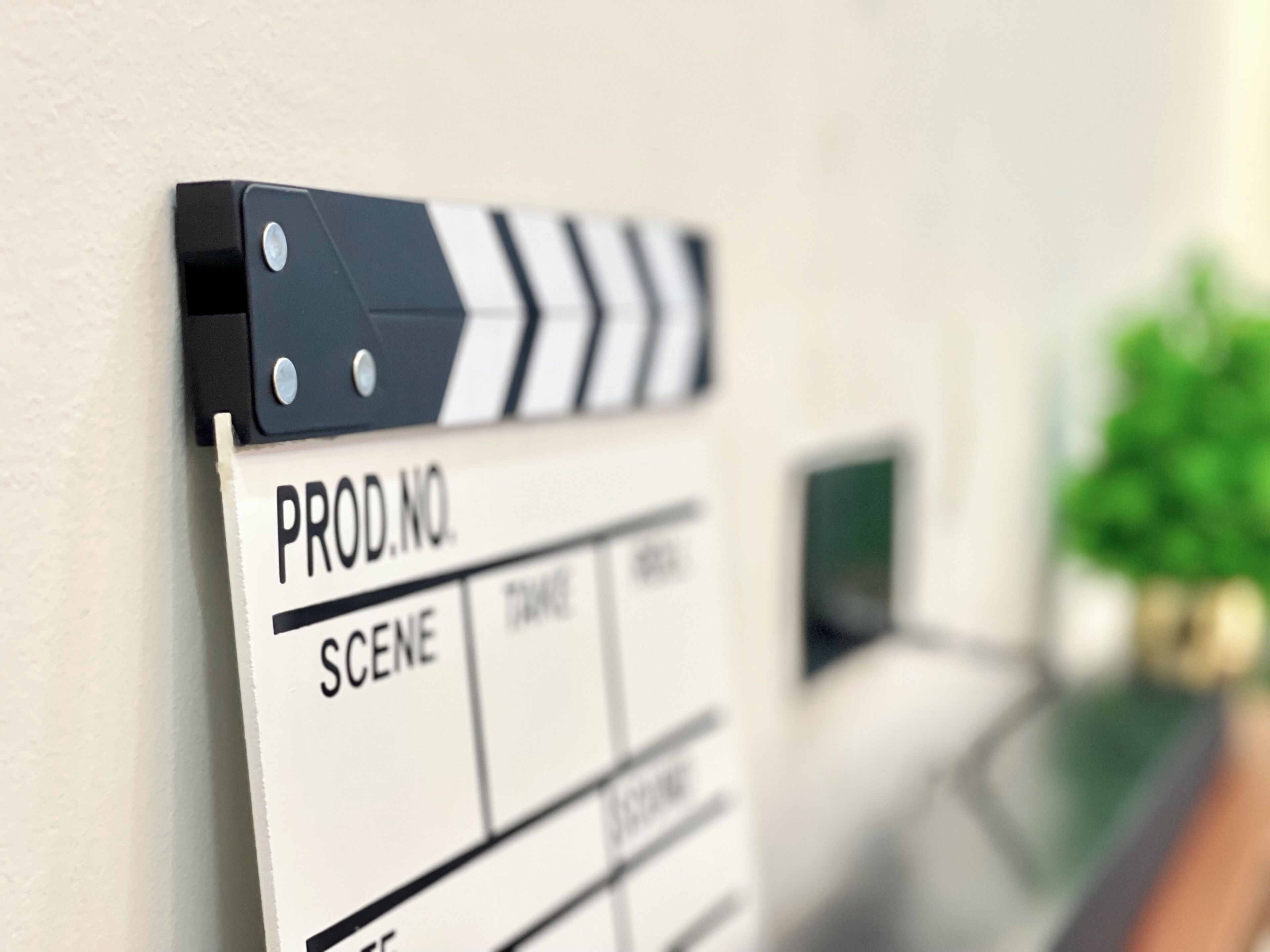 A clapperboard with 'PROD.NO.' and 'SCENE' labels, indicating a film production setting.