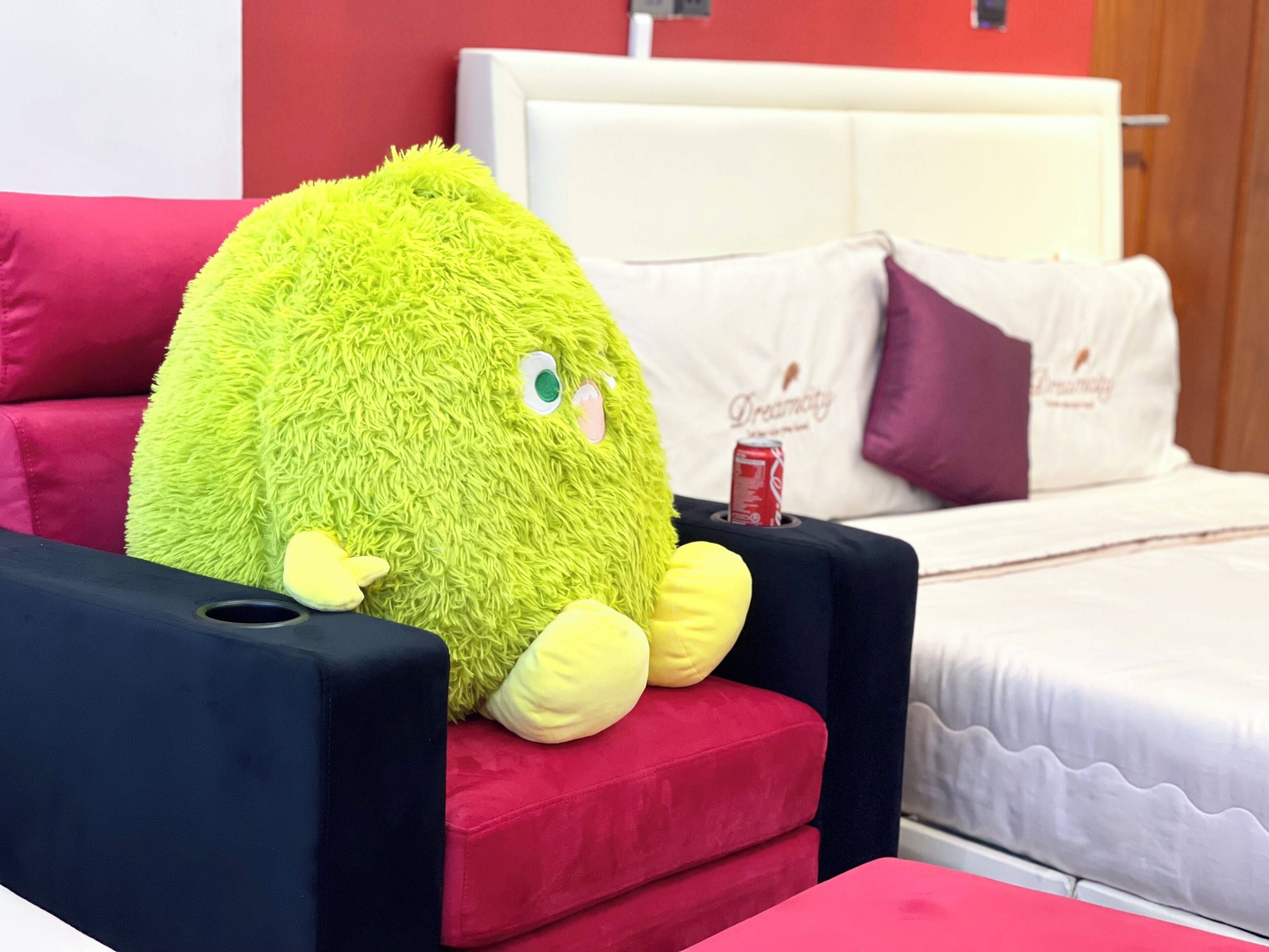 Un jouet en peluche est posé sur une chaise rouge dans une chambre d’hôtel.
