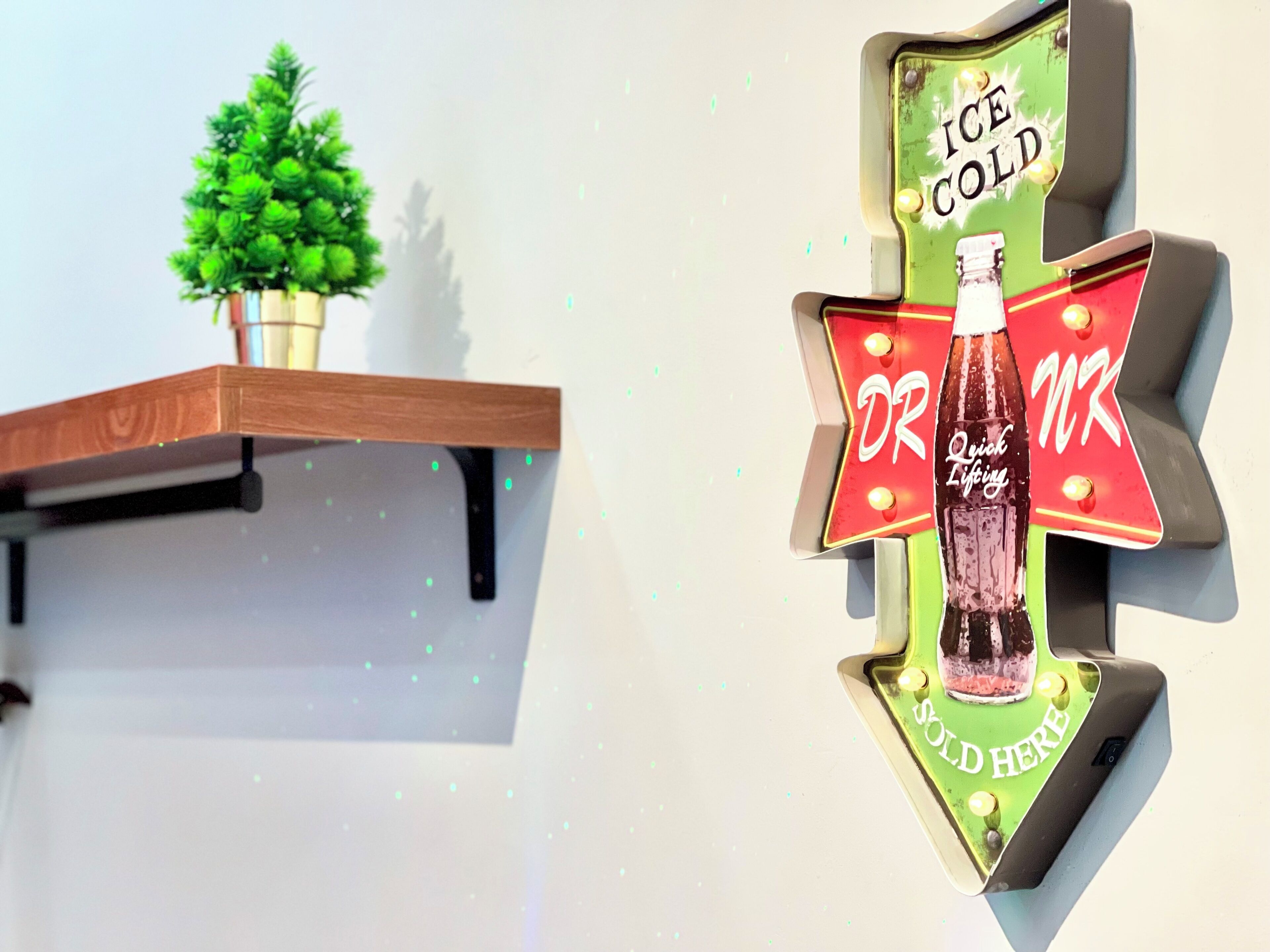 Un letrero en la pared con una botella de Dr. Pepper y el texto 'DR MR ICE COLD HERE'.