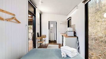 Een moderne slaapkamer met een bed, een kleine kitchenette en uitzicht op de omgeving.