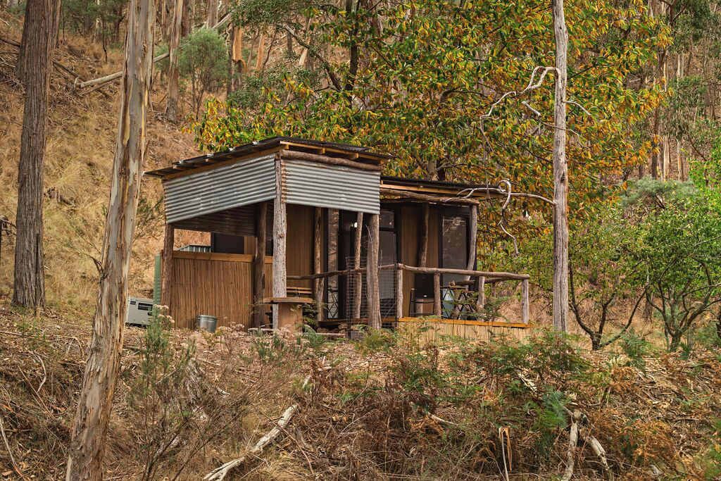 Eine rustikale Holzhütte mit Balkon und kleiner Veranda.
