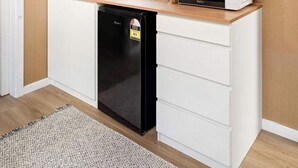 Una cocina compacta con lavavajillas integrado, microondas y cafetera.