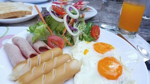 A plate with ham, eggs, and a salad.
