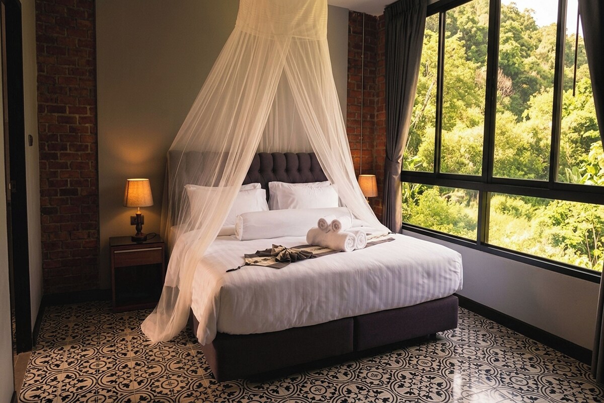 A bed with a canopy, two bedside lamps, and a view of greenery through a window.