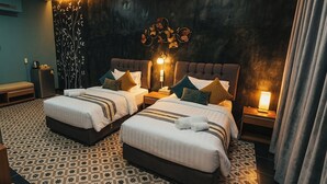 A hotel room with two beds, a large wall decoration, and a patterned floor.