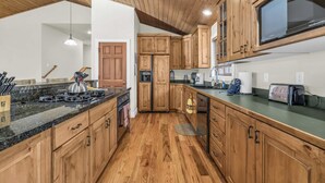Una cocina con armarios de madera, una estufa y un microondas.