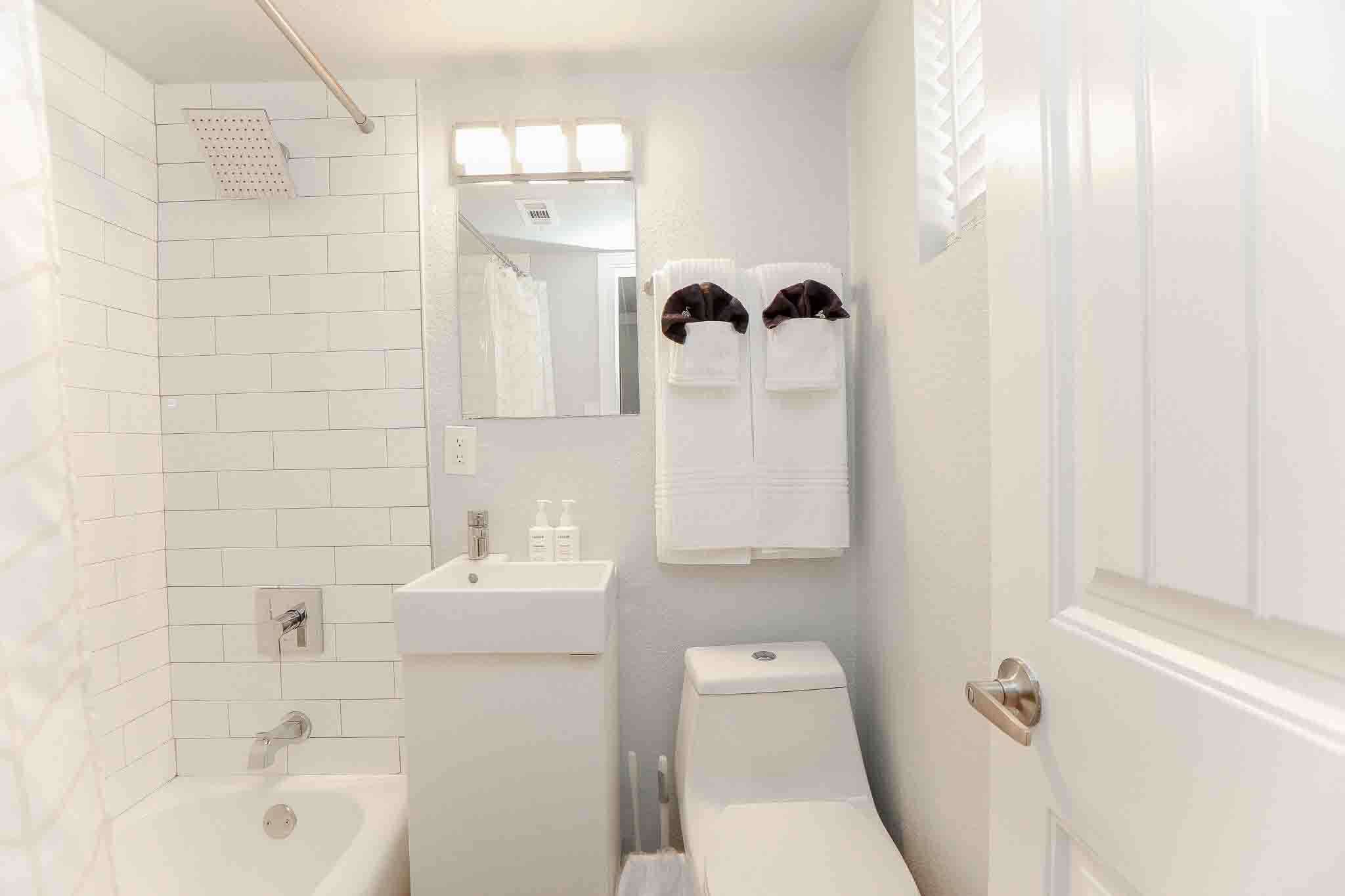 A compact bathroom with a shower, sink, and toilet.