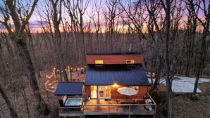 Une cabane dotée d’une terrasse, d’un bain à remous et d’un espace extérieur aménagé et abrité.