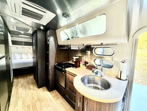 A compact kitchen with a stove, sink, and a small countertop area.