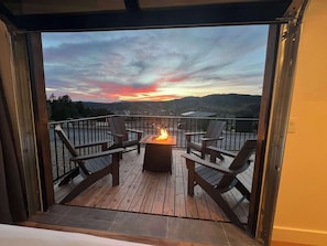 A deck with a fire pit and chairs, overlooking a scenic landscape. - Modern Cabin w/Resort Pool, Hot Tubs & Pickleball (Orderville)