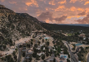 A mountainous landscape with a winding road, several buildings, and a swimming pool. - Glass Star Gazing Bedroom Cabin Near Zion & Bryce (Orderville)