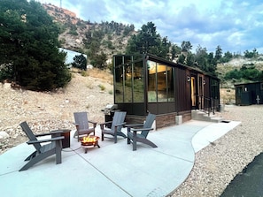 A modern cabin with a patio area featuring Adirondack chairs and a fire pit. - Stargazing cabin near Bryce & Zion w/resort pools (Orderville)
