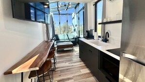 Een moderne keuken met een houten bar, een bank en een groot raam.