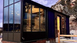 A modern building with large windows, a wooden base, and a stone exterior. - Stargazer Cabin near Zion with Glass Ceiling (Orderville)