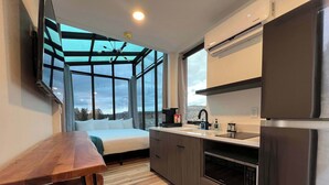 A modern kitchen with a large window, a built-in oven, and a refrigerator. - Stargazer Cabin near Zion with Glass Ceiling (Orderville)