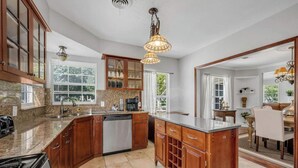 A kitchen with granite countertops, wooden cabinets, a dishwasher, and a stove. - The private home features two master suites with King beds and full attached bathrooms. The loft is 3rd private getaway with a Queen bed and attached full bath. Fully stocked kitchen and a separate Oak dining area. (Dallas)