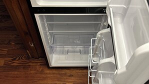 Un réfrigérateur ouvert, doté de deux étagères et d’un compartiment congélateur.