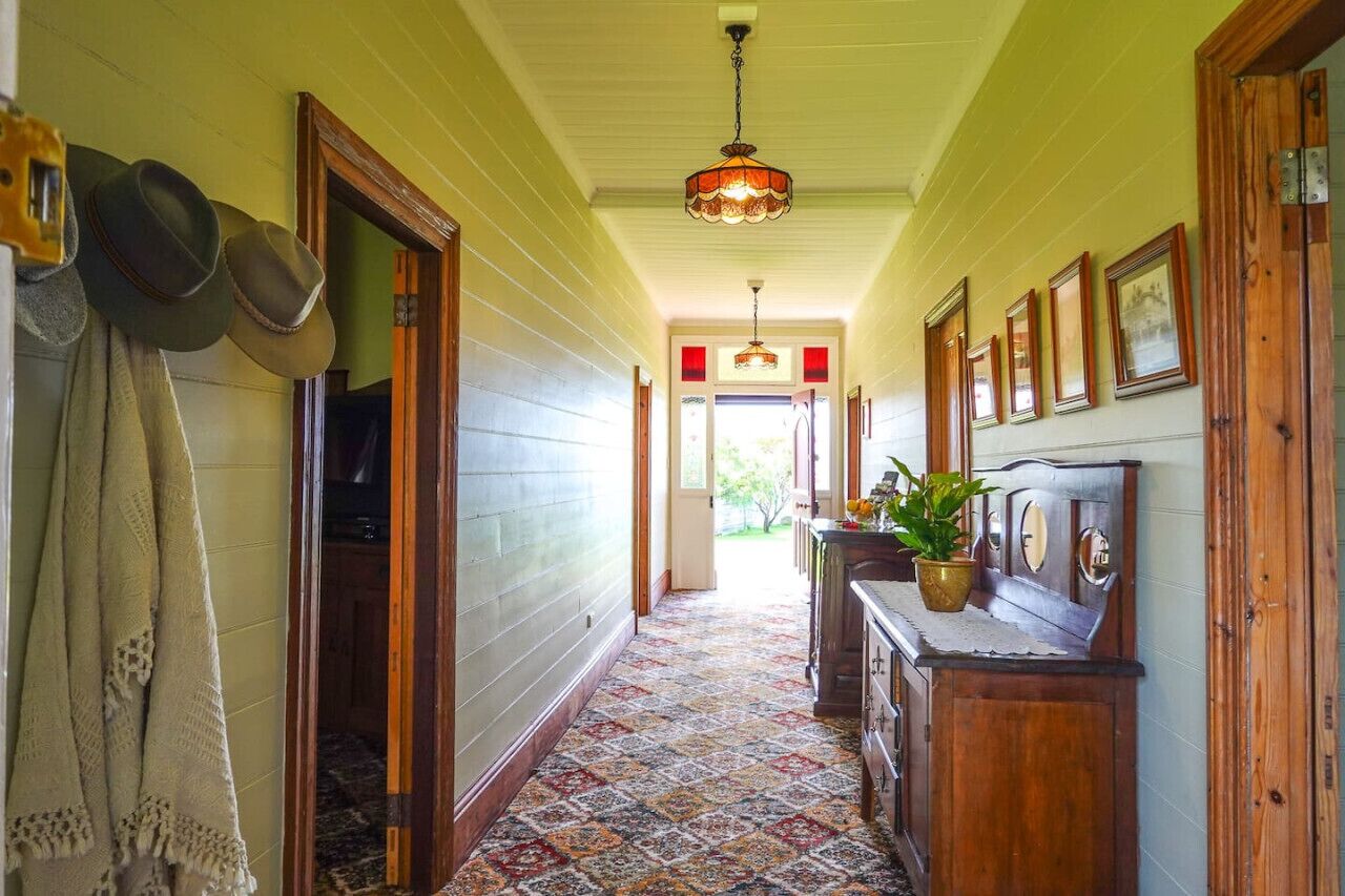A hallway with patterned carpet, wooden doors, and a ceiling light fixture.