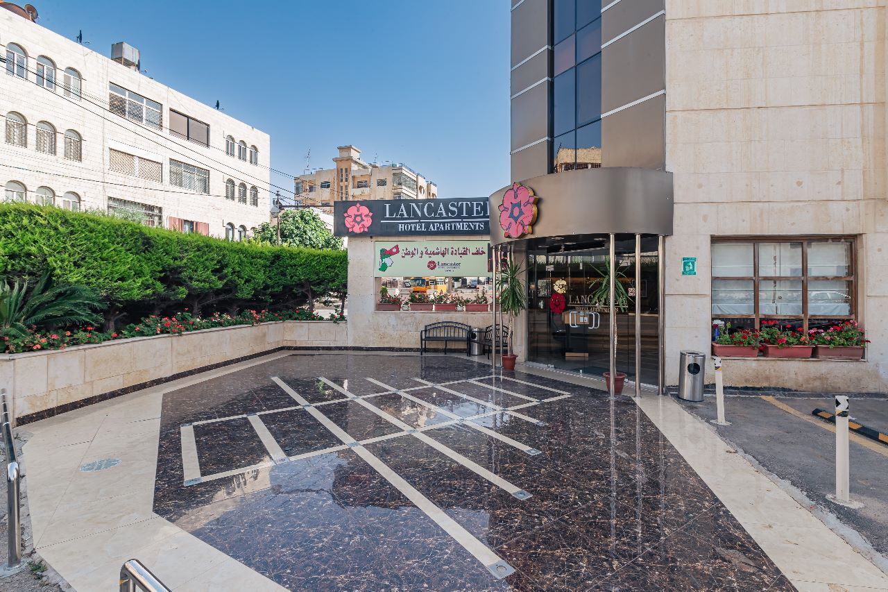 A hotel entrance with a sign reading "Lancaster Hotel Apartments".