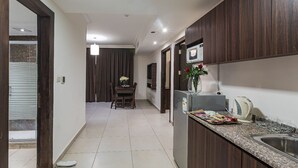 Una cocina moderna con armarios de madera oscura, encimera de granito y pileta de acero inoxidable.