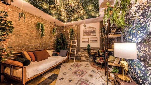 A cozy room with a wooden bed, a patterned rug, and a brick wall. - Bohemian Old Quebec Retreat | Exposed Brick & Character (Québec)