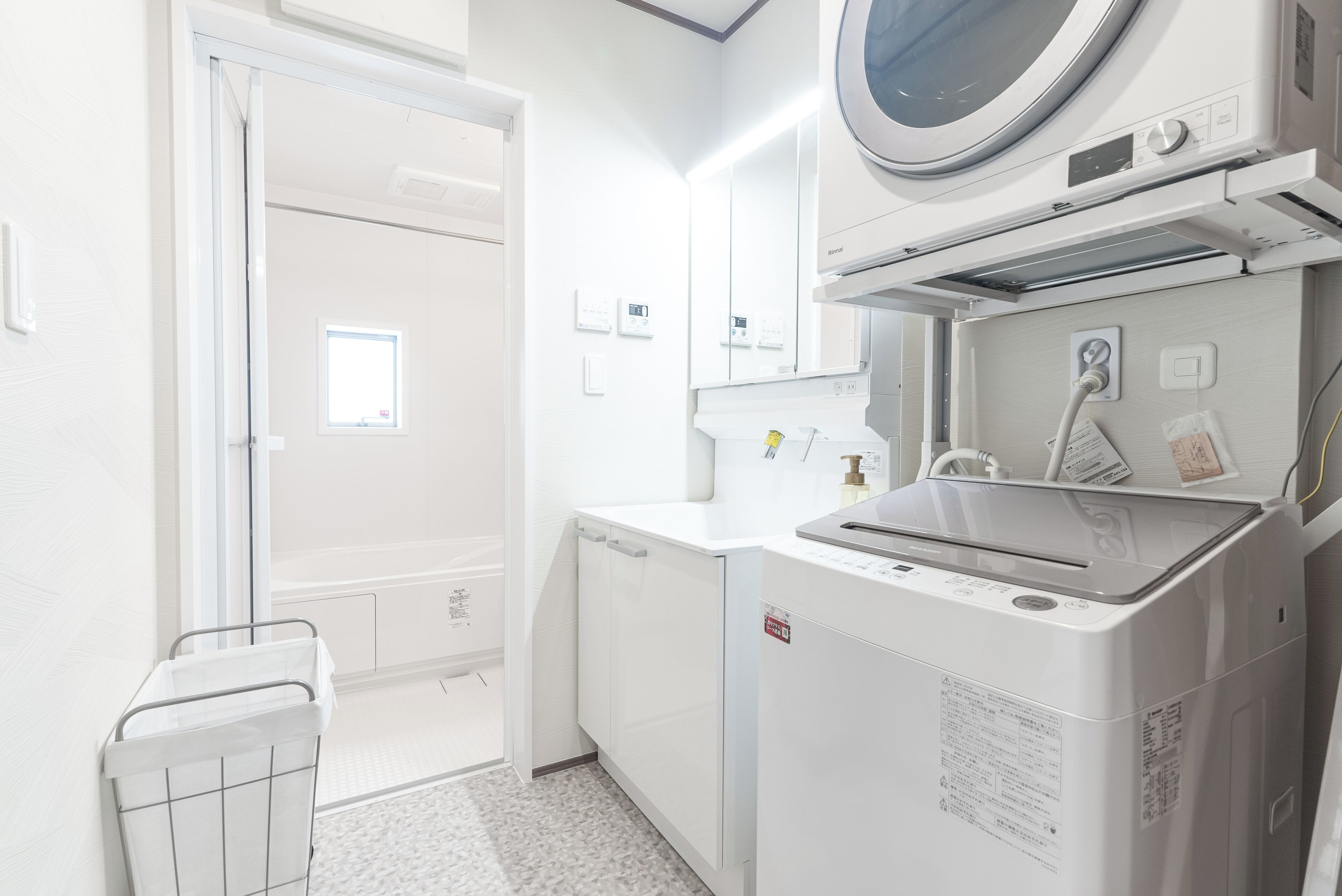 A laundry room with a washing machine, dryer, and a small window.