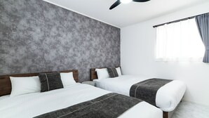 A modern hotel room with two beds, grey textured walls, a ceiling fan, and a window with curtains. - Grandioso Okinawa Pool Villa Onna 8 (Onna)