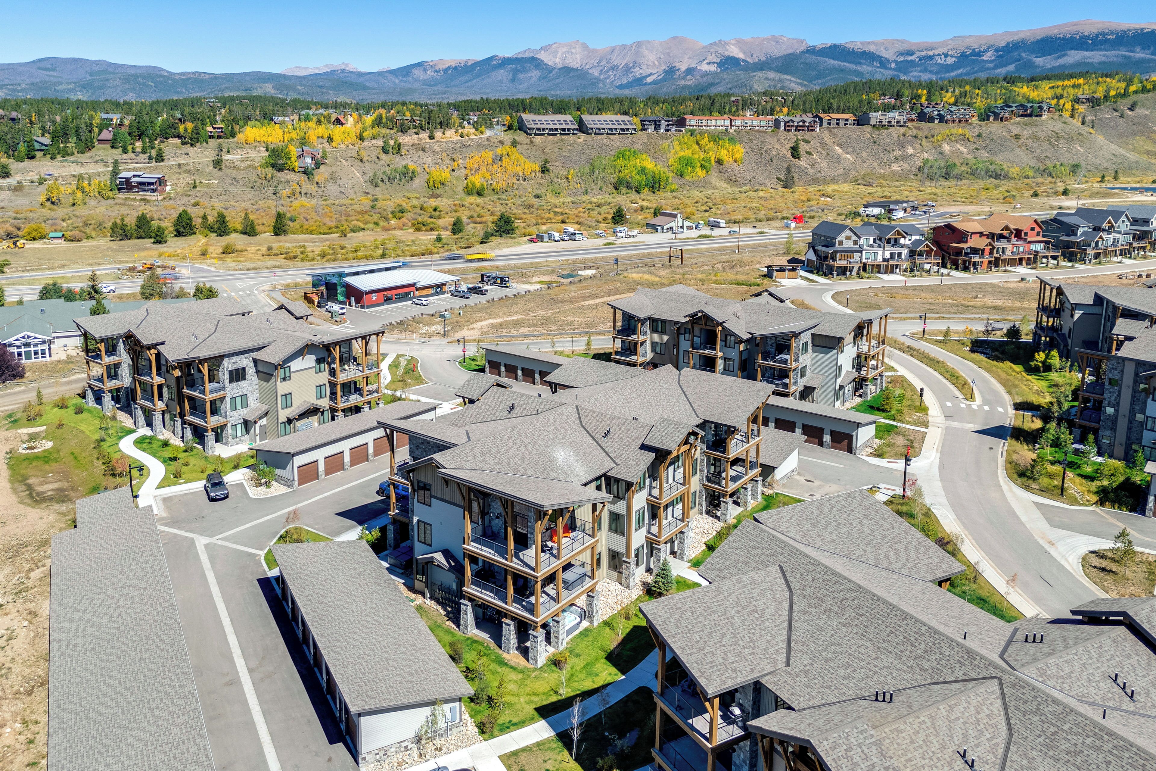 A residential area with modern houses, a road, and a mountain range in the background.