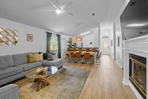 Un salon moderne avec un canapé, une table basse et une cheminée.