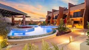 A modern hotel with a swimming pool, outdoor seating, and a sunset view. - New LUXE Townhouse 5 min walk Ritz/Palm Beach #15 (Noord)