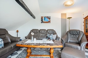 Un salon comprenant un canapé, une table basse et un tableau accroché au mur.