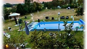 Un patio trasero con piscina, una carpa y un pabellón.