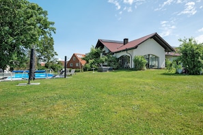 Ein Haus mit Swimmingpool, Rasen und Garten.