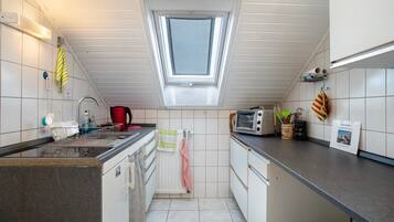 Een koelkast, een oven, een kookplaat, een koffiezetapparaat/waterkoker