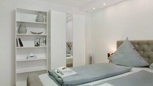 A modern hotel room with a bed, a wardrobe, and a mirror. - Apartment 'Neuburg 7 - New' with Balcony and Wi-Fi (Neuburg an der Donau)