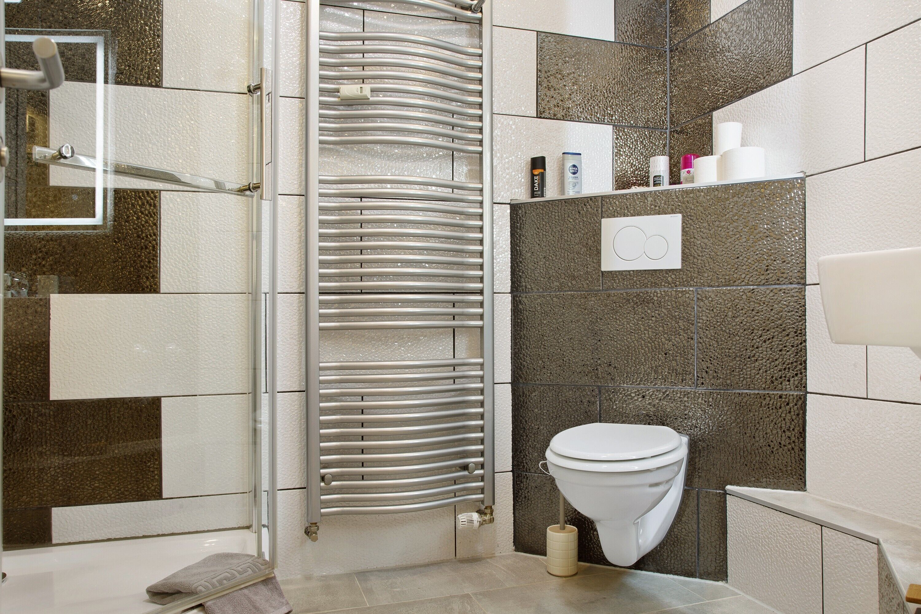 Un bagno con doccia, WC e portasciugamani.