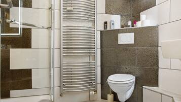 Un bagno con doccia, WC e portasciugamani.